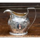A George III silver helmet shaped cream jug, London 1802, the body with scrolled foliage,