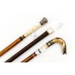 Three ivory/bone handled walking canes, one with silver collar and one with silver knop handle,