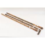 A bamboo walking cane carved with Oriental figures,