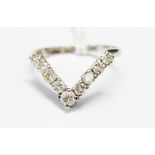 A diamond wishbone 18ct white gold ring, nine graduating diamonds,