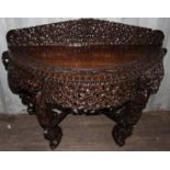 A late 19th Century Burmese carved hardwood demilune console table,