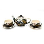 Moorcroft bramble teapot with two matching cups and saucers