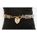 A nine carat gold gate bracelet with a heart locket clasp, approx weight 5.