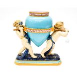 A 19th Century Majolica figural vase, the amphora shaped vessel supported by two putti,