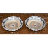 A pair of Victorian silver plate coasters, the rims chased with vine leaves and trailing vine,