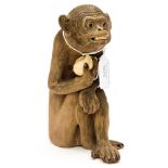 An unsigned Japanese stoneware monkey figure 20th Century with teeth and holding a fruit