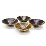 A set of four Chinese relief moulded and sgrafitto bowls decorated with dragons, cranes,