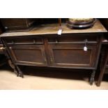 A 1920s oak sideboard with two drawers over two doors,