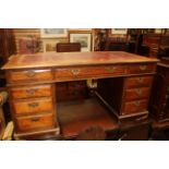 An Edwardian mahogany twin pedestal desk, the top with a leather inset writing surface,