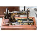 A 1900s Singer 48k Transvere Shuttle 'Ottoman' or 'Peacock Tail' design case sewing machine