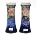 A pair of Royal Doulton vases with a pink vase tube line decoration on blue fading ground (2)