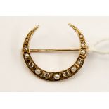 A crescent shaped metal brooch,