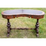 A Victorian walnut kidney shaped writing desk, the top inset with leather,