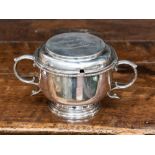 An Edwardian silver porringer and cover, the plain circular body on reeded foot, S-scroll handles,