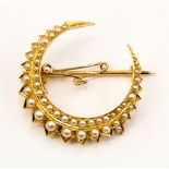 An old gold metal crescent brooch set with seed pearls, not hallmarked but tested as gold,