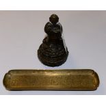 A brass oval dish, standing on foliate feet, having raised decoration to the inside,