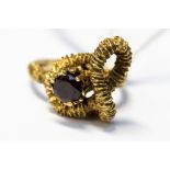 A garnet set 9ct yellow ring, the round mixed cut garnet set in textured rope effect mount,