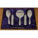 A Victorian style silver mounted vanity set, including two parts of brushes, hand mirror and comb,