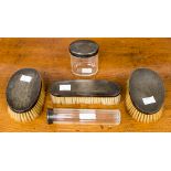 A George V silver toilet set including glass jars and silver backed brushes, Adie Bros,