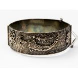 A white metal hinged bangle having Turkish applied decoration,