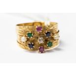 An 18ct gold multi band ring, set with pearls, diamond, rubies and sapphire and emeralds,