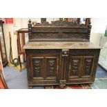 A Victorian oak dresser, two doors, six bun feet, heavily carved to front,