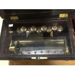 A nine Bells music box, brass cylinder with tines, inlaid work to the hinged lid and front,