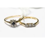 Two diamond rings, comprising a three stone rub over set ring, in 18ct gold,