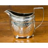 A Georgian silver cream jug with later embossed decoration of floral swags,