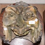 A carved stone head in the form possibly 'Green Man' head,