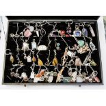 A presentation case containing an extensive collection of white metal (stamped 925) pendants,