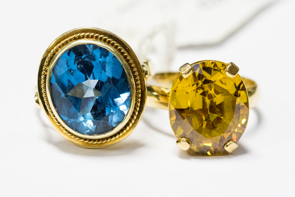A 14ct gold ring set with a large oval blue topaz, with a rub over setting and rope detail,
