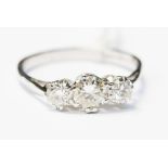 An 18ct white gold ring set with three diamonds, central diamond equates 0.