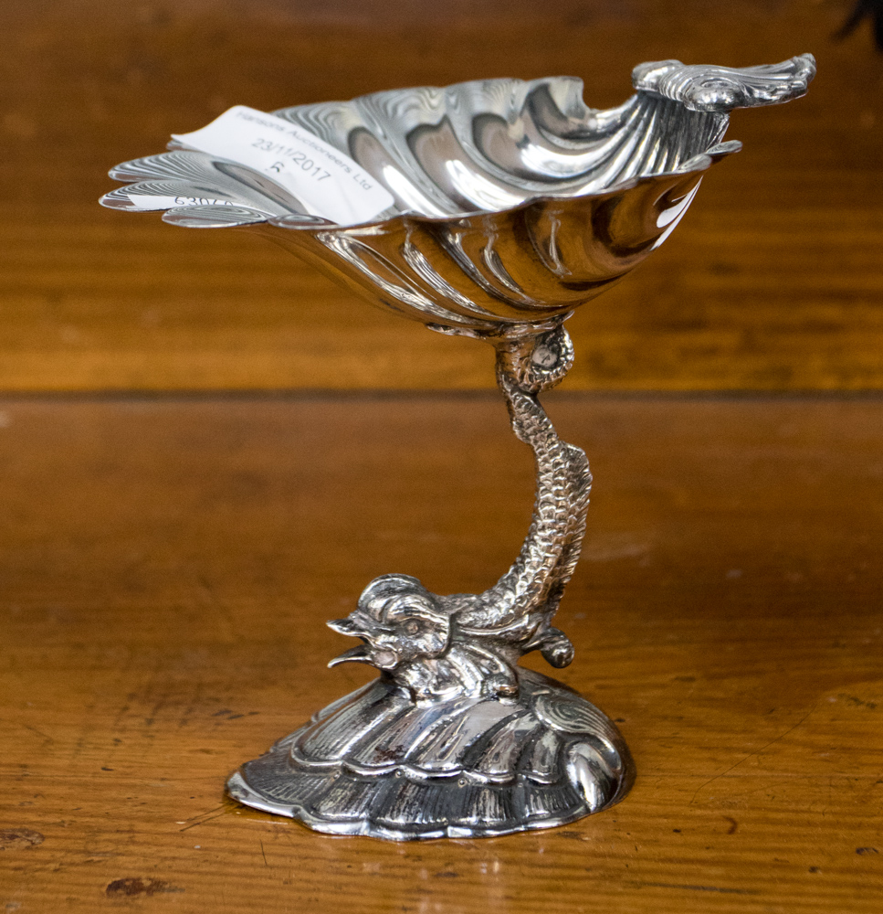 A silver plate Victorian style bon bon dish, shell bowl above Dolphin support on stylised wave base,