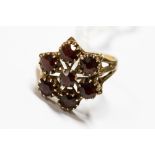 A garnet cluster ring set in a star shape in 9ct gold, setting size approx 15mm,