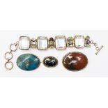 A collection of three brooches, comprising a moss agate circular brooch,