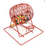 A vintage Bingo ball dispenser, circa 1960's, red plastic bound wire construction, with balls,