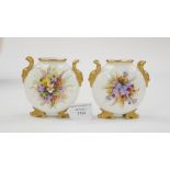 A pair of Coalport florally decorated moonflasks on gilt horn feet and mask handles (2)