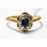 An 18ct gold ring, set with a central sapphire (a/f) surrounded with diamond chips, size Q,