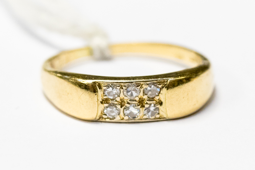 An 18ct gold ring pave set with six small diamonds, approx 0.