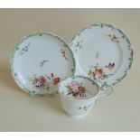 An English porcelain tea cup and saucer and plate, floral decorated with green and gilt borders,