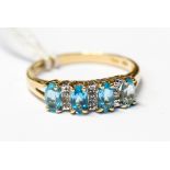 A 9ct and blue topaz ring, comprising four oval blue topaz stones claw set,