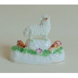 A rare Staffordshire porcelain model of a Ewe standing on a mound, surrounded by grass,