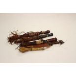 A collection of four African tribal daggers and scabbards along with a small wooden African cosh