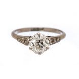 A diamond solitaire platinum ring with diamond set shoulders,