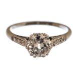 A diamond solitaire white gold ring with diamond set shoulders,