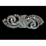 An Art Deco diamond double clip mounted on bar brooch of stylised scroll openwork form,