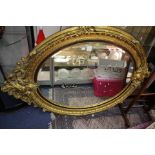 An 18th Century style oval gilt mirror with acanthus leaf and 'C' scroll detail,
