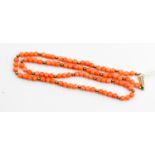 A string of coral type beads on 9ct gold clasp