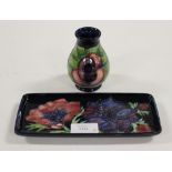 A Moorcroft blue ground pin tray and a small baluster shaped vase, both tube lined,